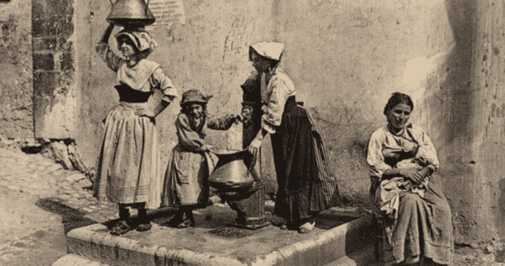 Donne ciociare in abito tradizionale che si recano a una fontana per riempire le conche